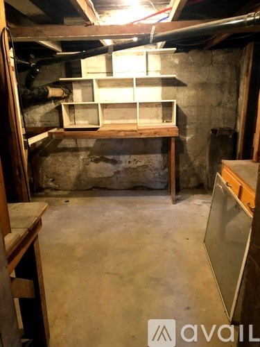 A room with a lot of clutter and a wall that is not finished.