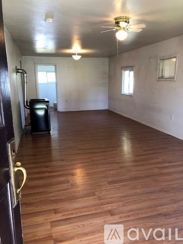A room with wooden floors and a ceiling fan.