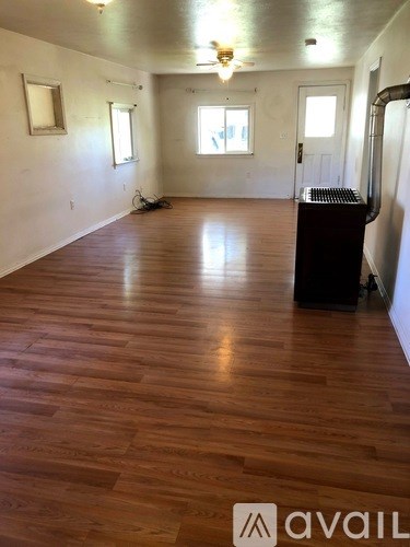 A room with wooden floors and a ceiling fan.