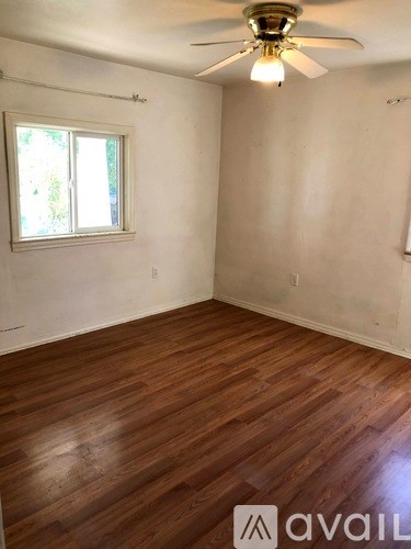 A room with wooden flooring and a ceiling fan.