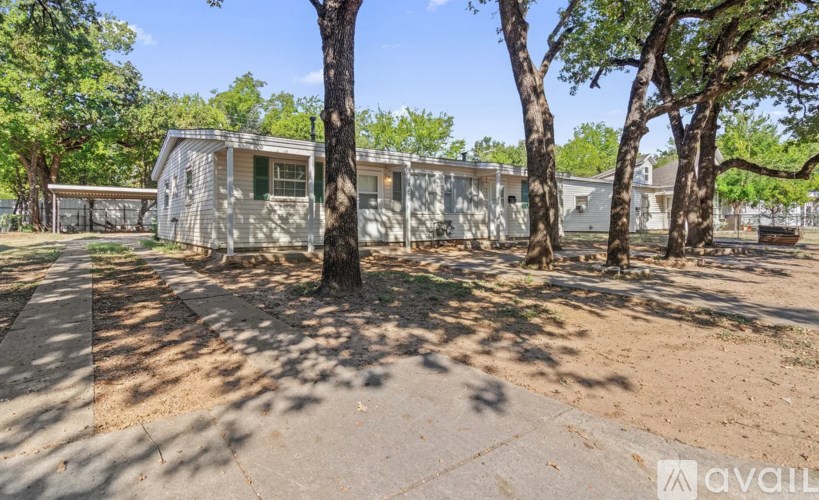 A row of houses with trees in front.