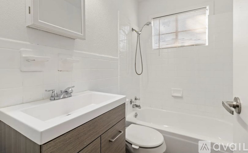 A white bathroom with a sink, toilet, and bathtub.
