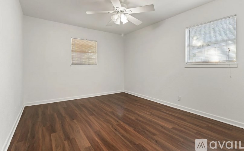 A room with wooden flooring and a ceiling fan.