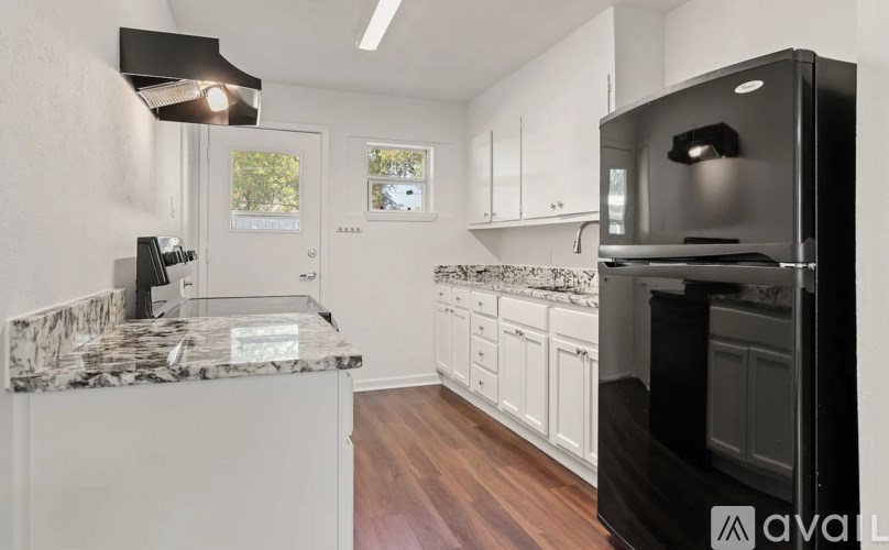 A kitchen with a granite countertop and white cabinets.