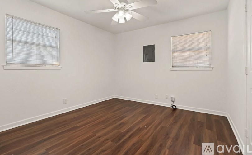 A room with wooden floors and a ceiling fan.