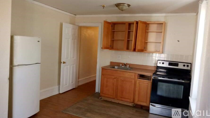 A kitchen with wooden cabinets and a white fridge.