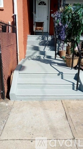A set of concrete stairs leading to a white door.