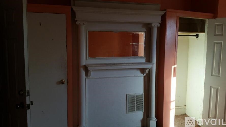 A white door is open to a room with a window.