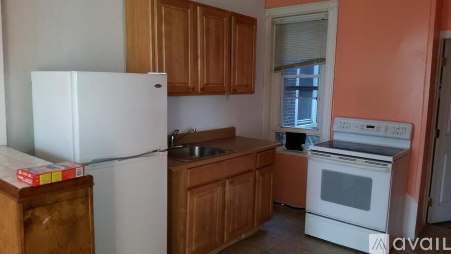 A kitchen with a white fridge, wooden cabinets, and a white oven.