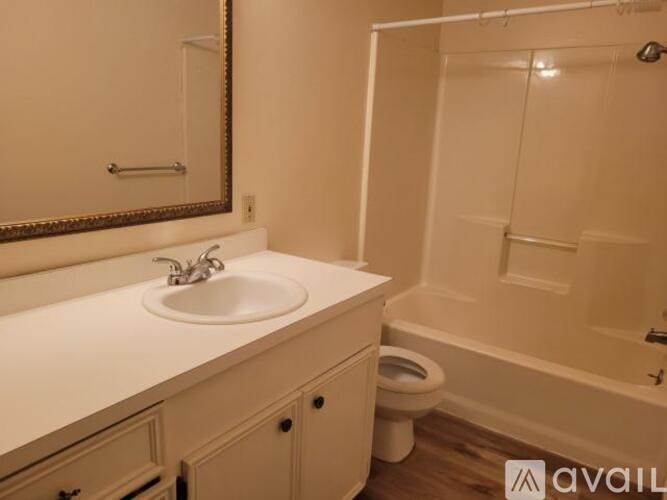 A bathroom with a sink, mirror, toilet and bathtub.