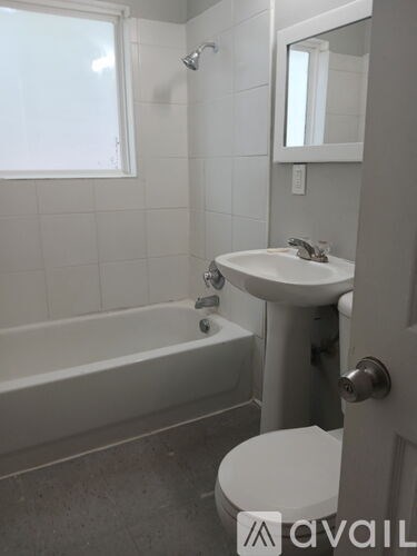 A bathroom with a white tub, sink, and toilet.