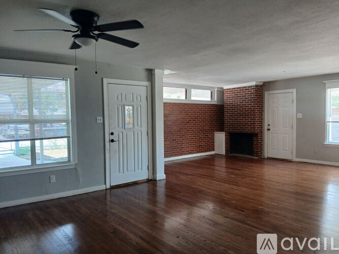 A room with a ceiling fan and wooden floors.