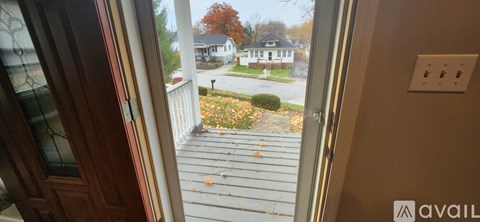 A view of a house from a window with a glass door.