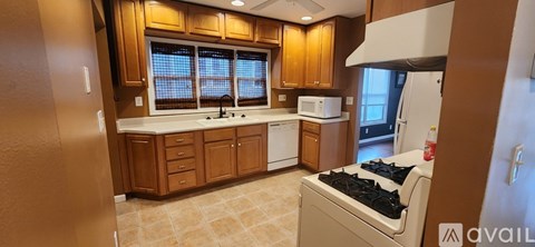 A kitchen with wooden cabinets and a white countertop.