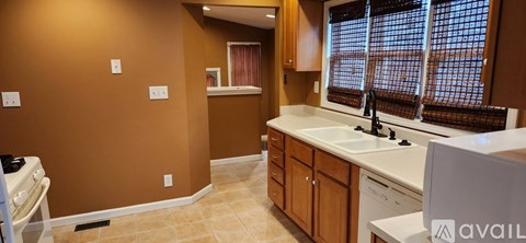 A kitchen with brown walls and a white sink.