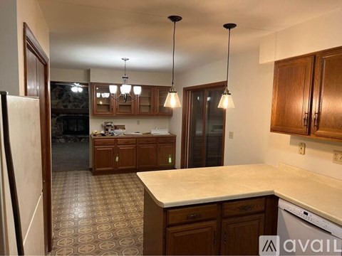 A kitchen with wooden cabinets and a marble countertop.