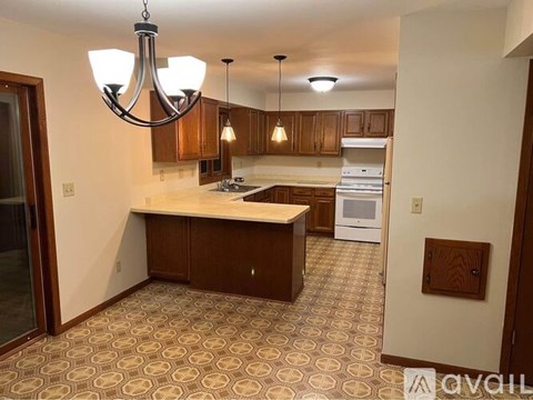 A kitchen with a patterned floor and a chandelier hanging from the ceiling.