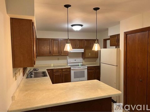 A kitchen with wooden cabinets and a white countertop.