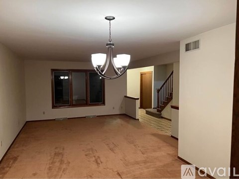 A room with a chandelier and a window.