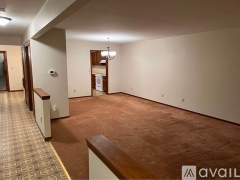 A room with a patterned carpet and a wooden bench.