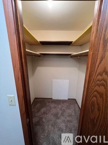 A small, empty room with a wooden door frame and a light switch on the wall.