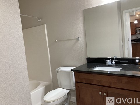 A bathroom with a toilet, sink, and mirror.