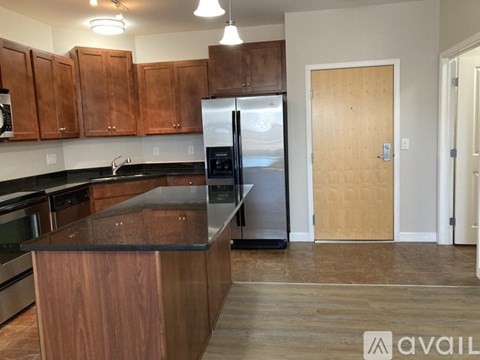 A kitchen with wooden cabinets and a black countertop.