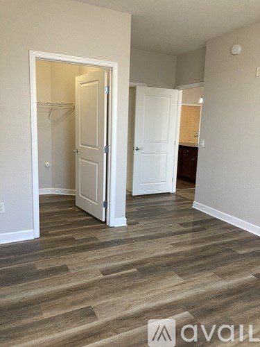 A room with a wooden floor and two white doors.