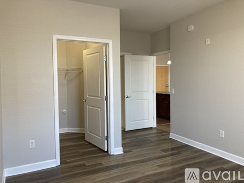 A room with a white door and a wooden floor.