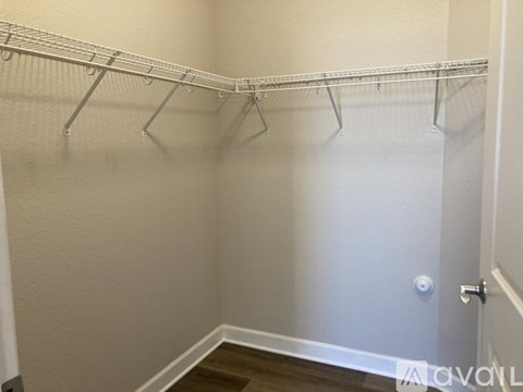 A white closet with a white door and a white shelf.