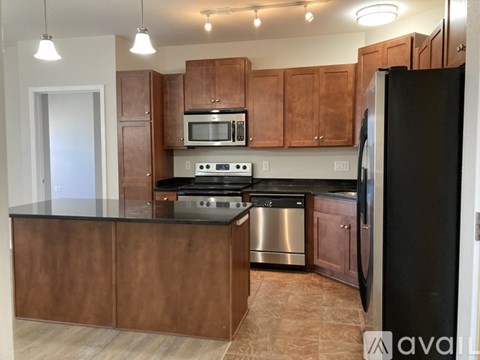 A kitchen with brown cabinets and black appliances.