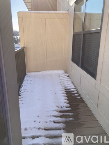 A balcony with a wooden floor and a wall.