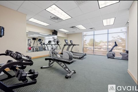 A gym with a variety of equipment including treadmills, weights, and exercise machines.