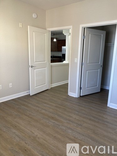 A room with a white door and a wooden floor.
