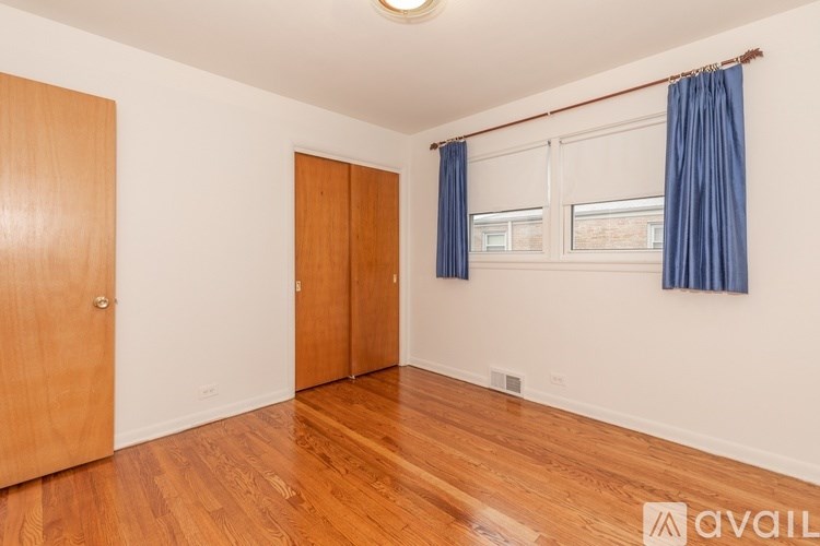 A room with wooden floors and two doors.