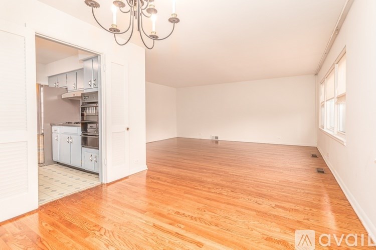 A room with wooden floors and a chandelier.
