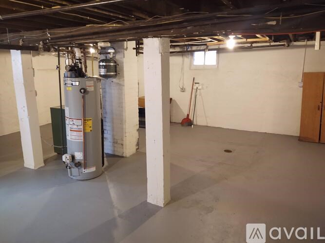 A large industrial room with a grey floor, white walls, and a ceiling with exposed ductwork.