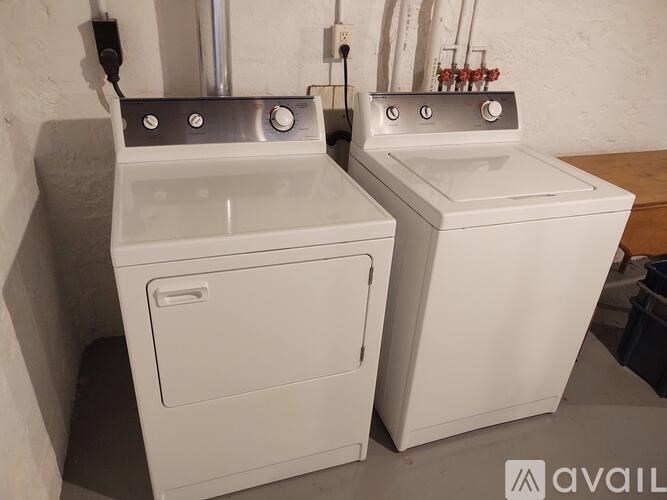 Two white ovens with black knobs and handles are in a room.