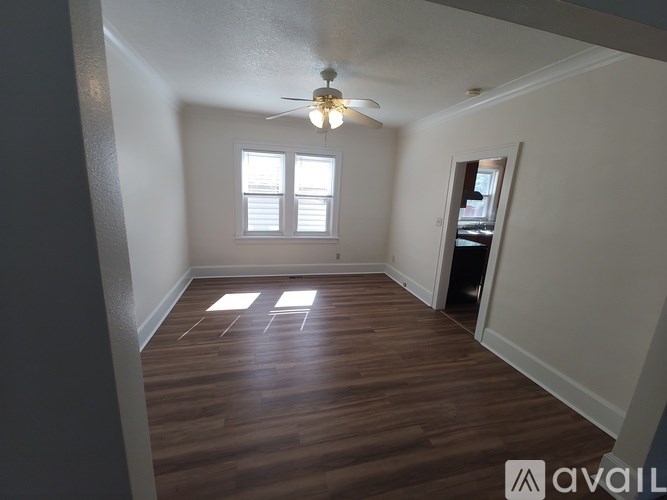 A room with wooden flooring and a ceiling fan.