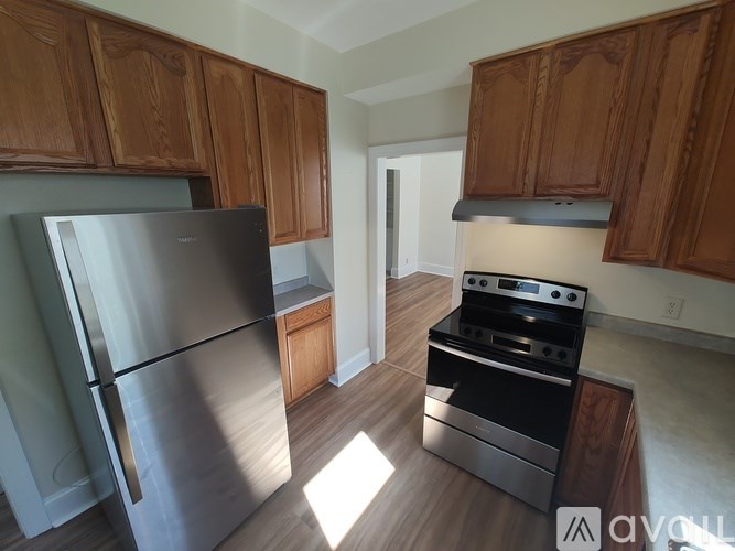 A kitchen with wooden cabinets and a stainless steel refrigerator.