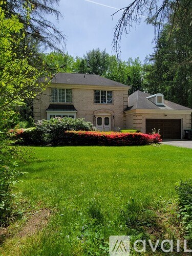 A house with a well-maintained lawn and a garden in front.