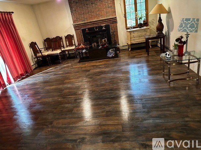 A living room with a fireplace and a glass table.