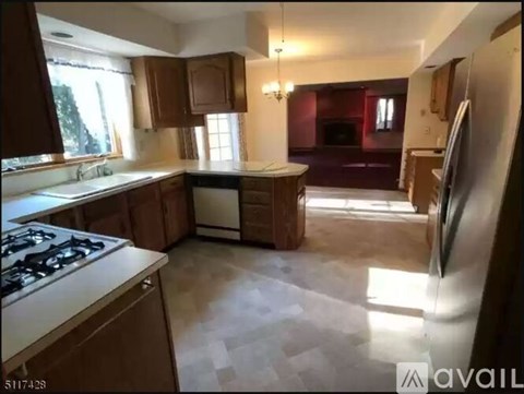 A kitchen with wooden cabinets and a white stove top oven.