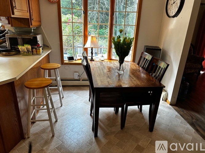 A kitchen with a table and chairs in front of a window.