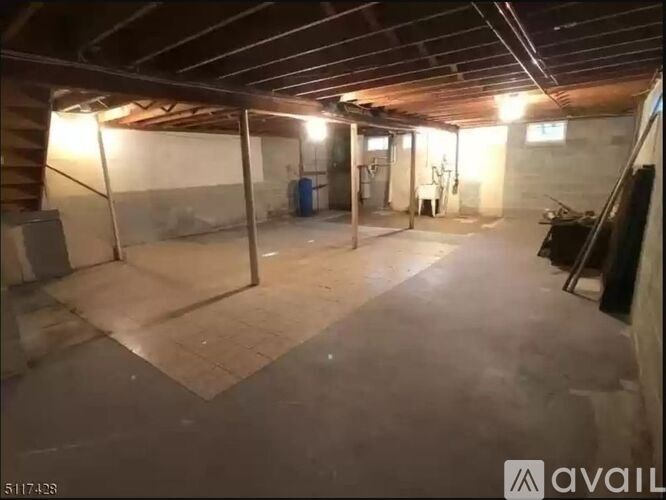 A spacious unfinished basement with a concrete floor and walls.