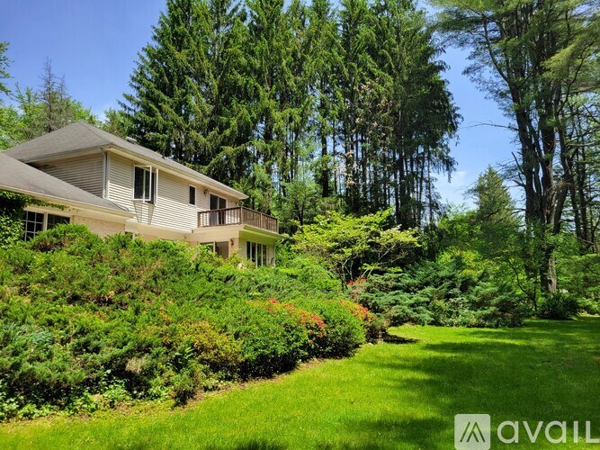 A house is for sale in a lush green area.