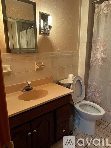 A bathroom with a toilet, sink, and mirror.