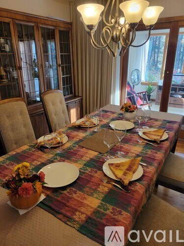 A dining table set for a meal with a chandelier above it.