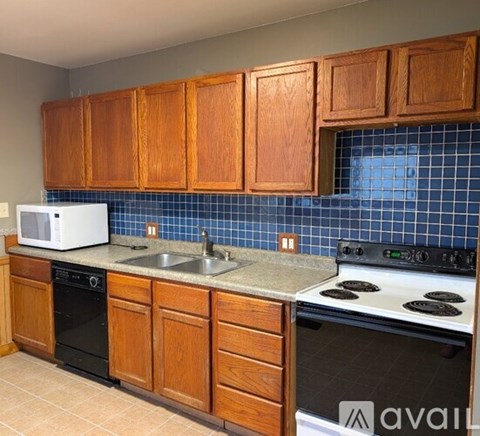A kitchen with wooden cabinets and a white microwave.