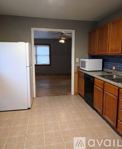 A kitchen with a white refrigerator and wooden cabinets.